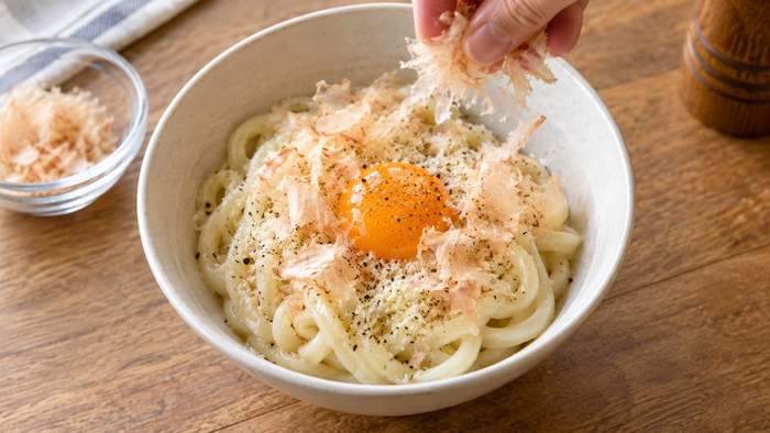 ぶっかけうどんの仕上げに、ベーコン節®を削ってのせているところ