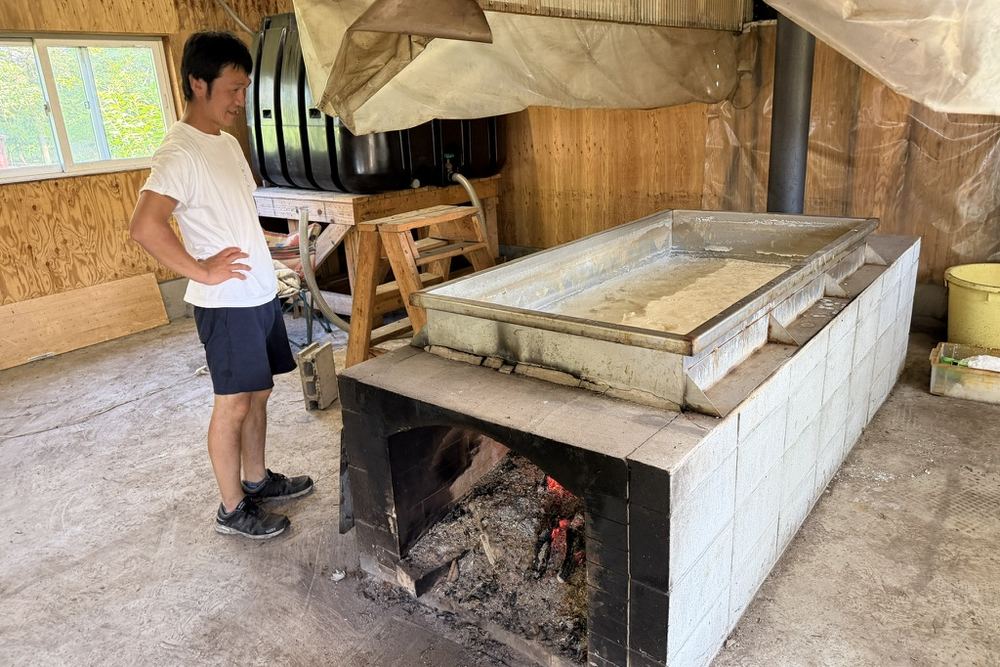 鈴木牧場の塩工房で、火にかけた鍋で海水を煮詰めて塩をつくる設備